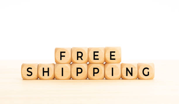 Free shipping phrase in wooden blocks on table. White background. Copy space